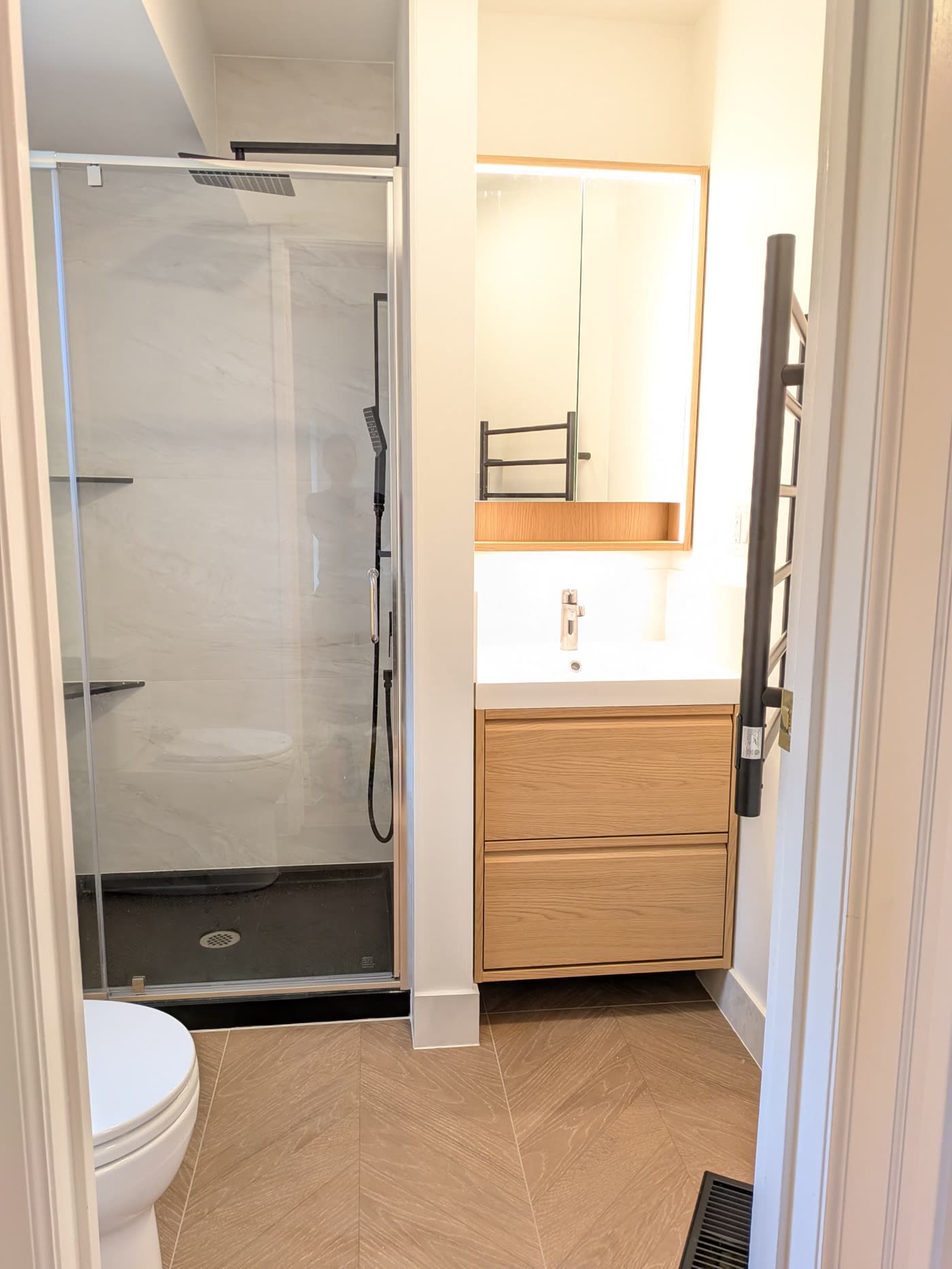 Completed Burnaby shower bathroom with glass enclosure and floating vanity
