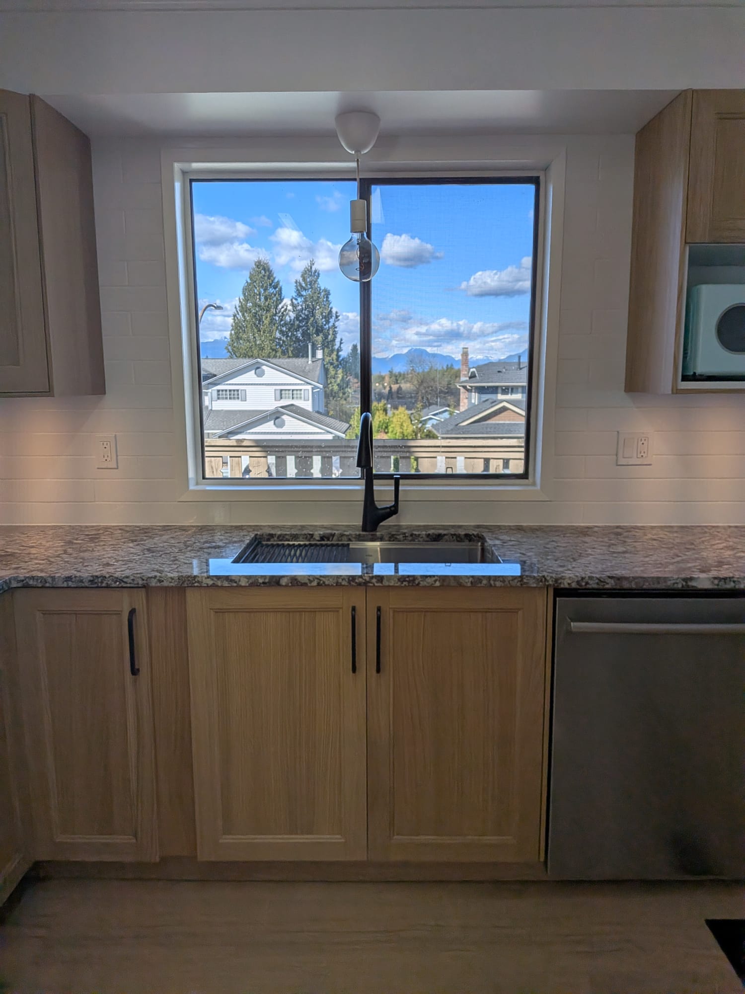 Budova kitchen renovation with sink, wood cabinets, countertop and finished backsplash