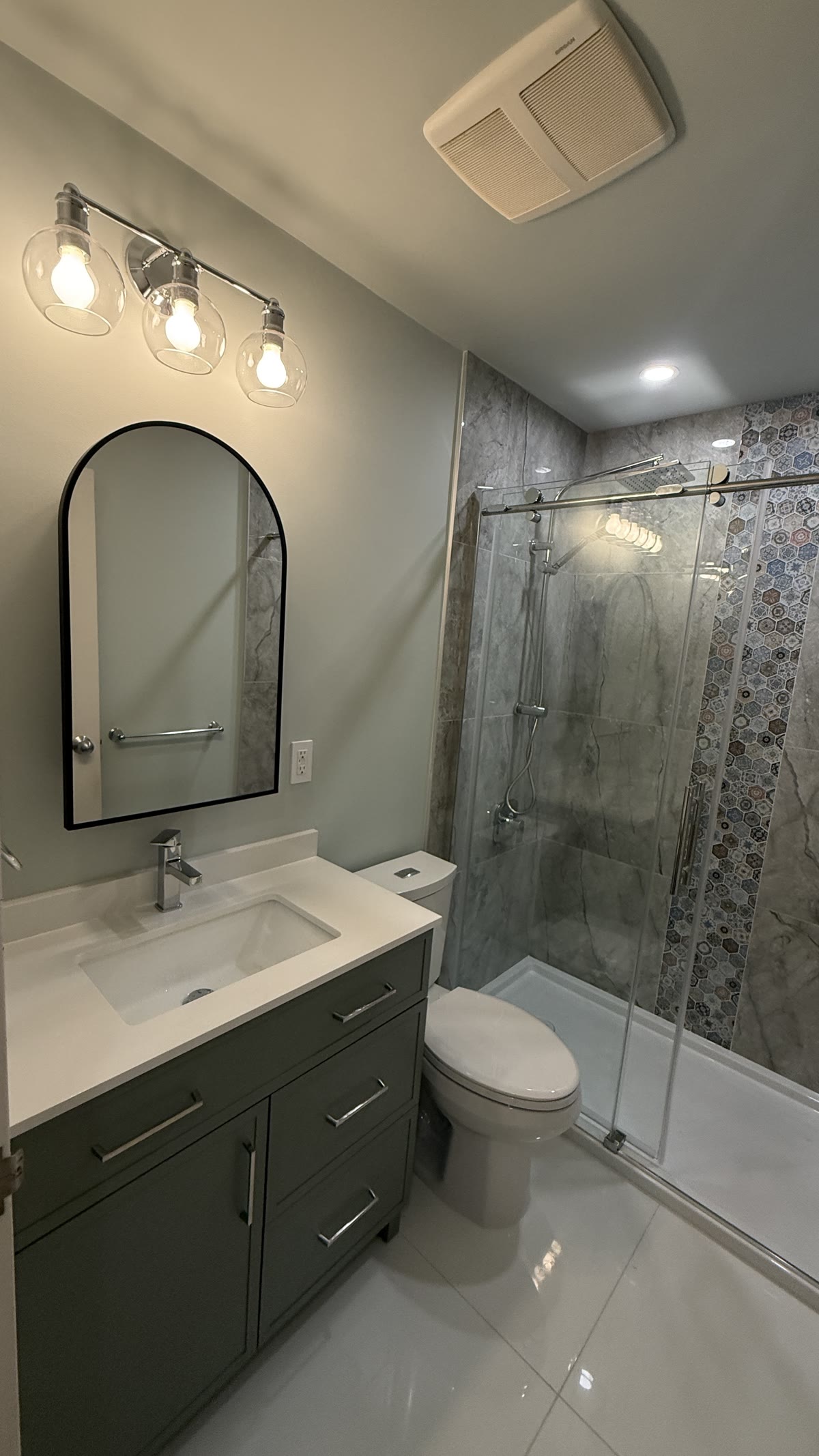 New vanity mirror lighting and tiled shower in a New Westminster bathroom