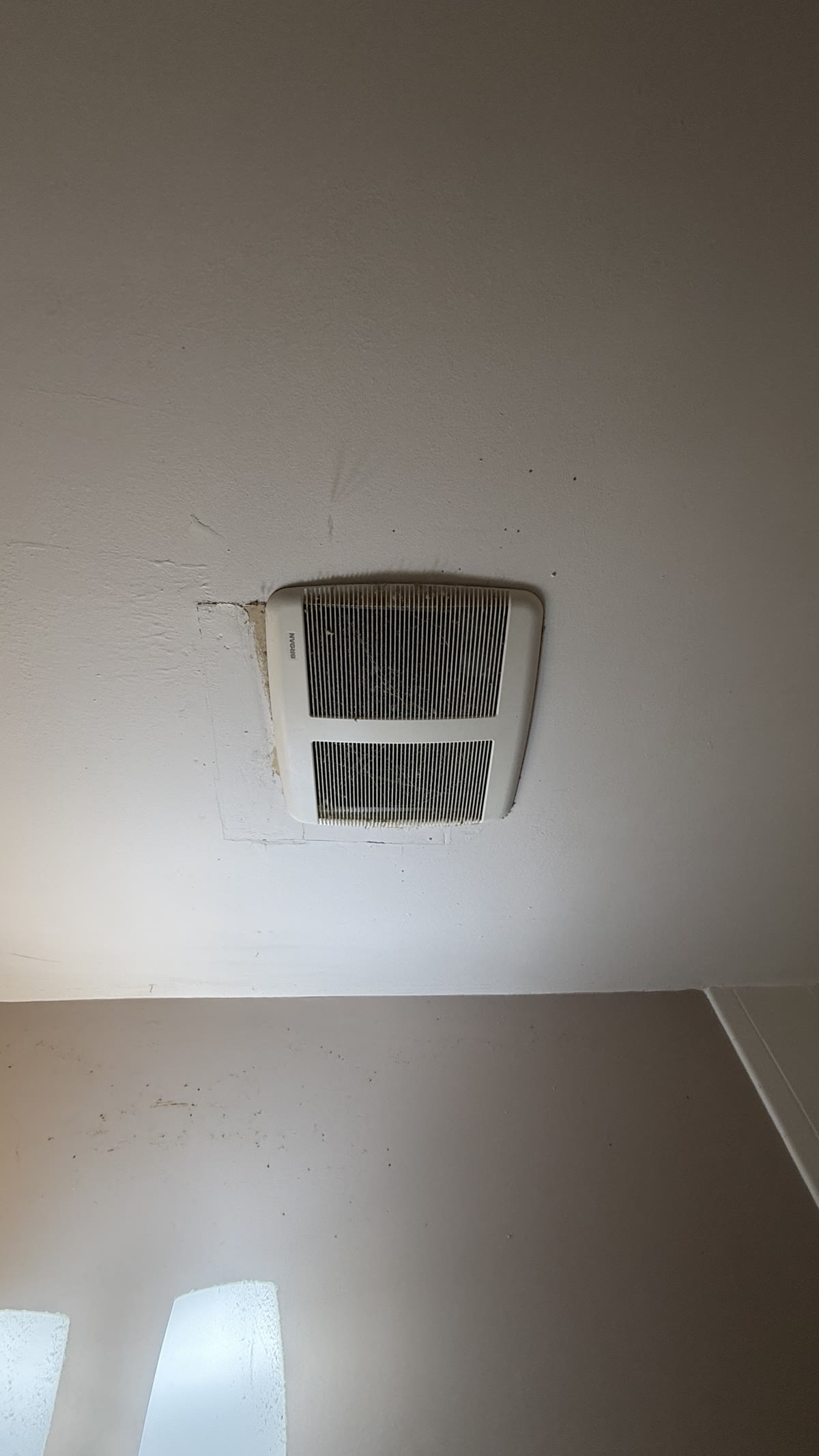 Bathroom ceiling and exhaust fan before repainting and renovation