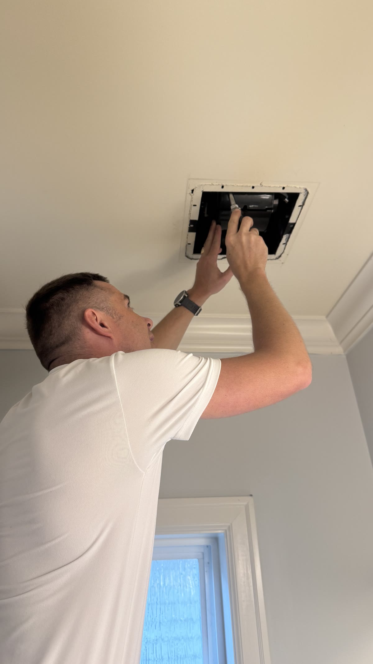 Alex replacing a ceiling exhaust fan during a Budova handyman service visit