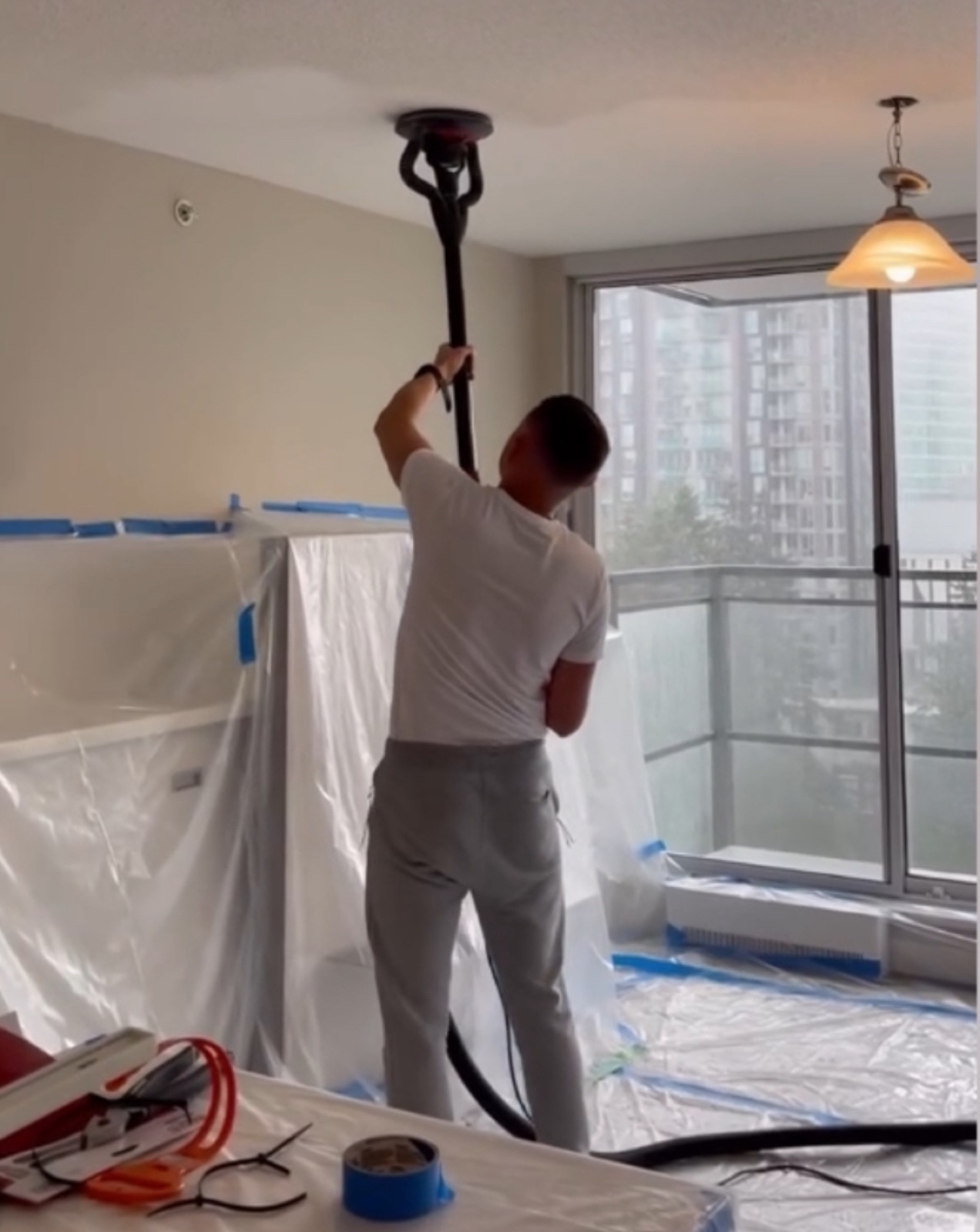 Budova removing a popcorn ceiling with floors and furnishings protected