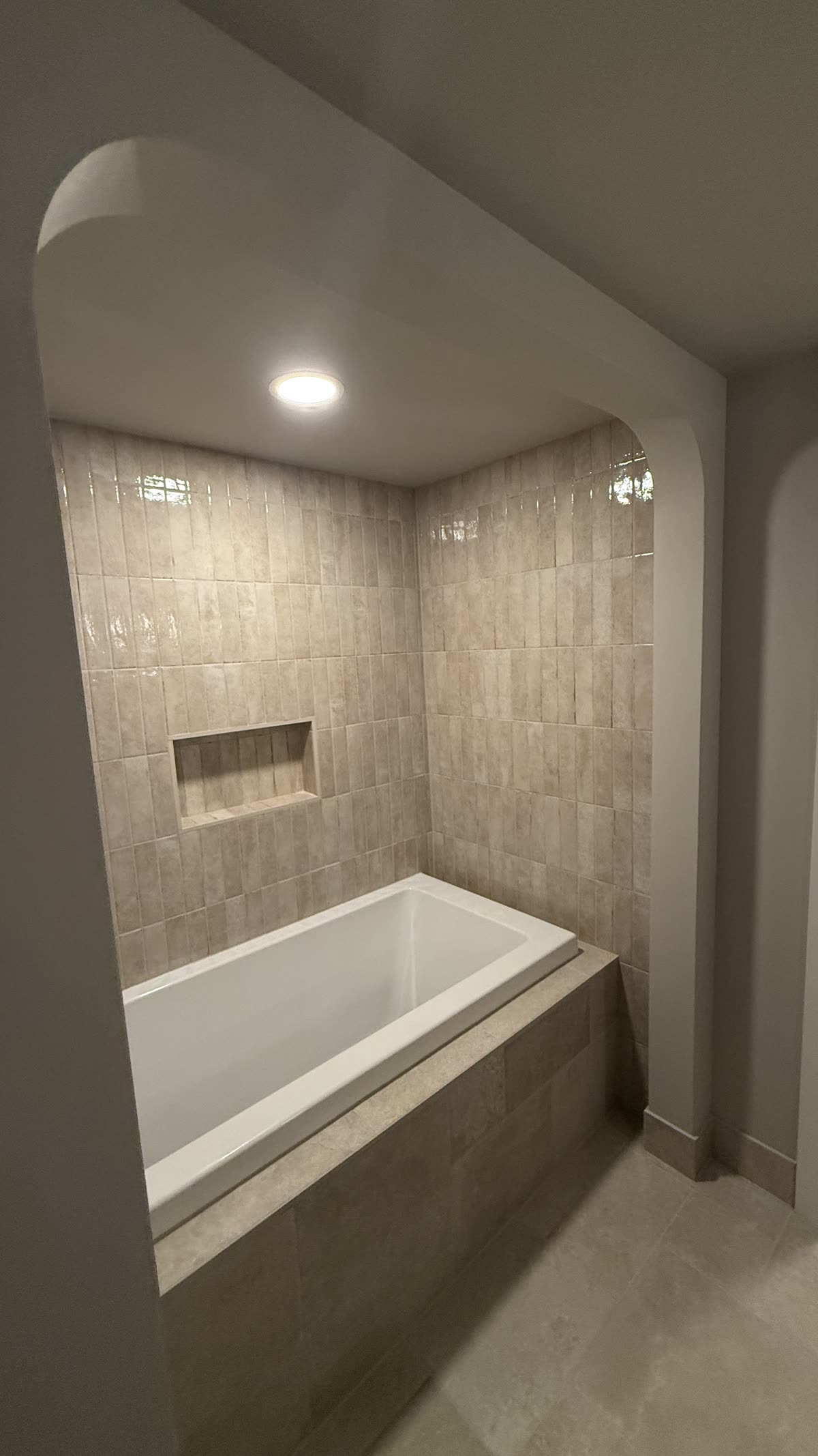 Finished Vancouver bathtub renovation with custom arched opening and tiled niche