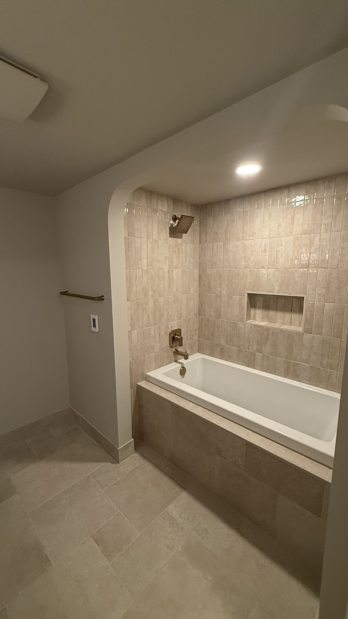 Renovated bathtub with small-format tile and niche in Vancouver